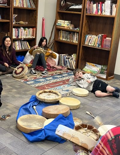 students on the floor with Native American drums spread out in front of them