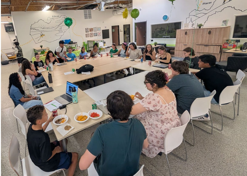 students of the Teen Leadership Committee sitting around tables arranged in a square