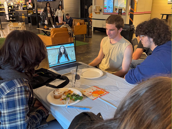students at October TLC meeting watching a video on a laptop computer